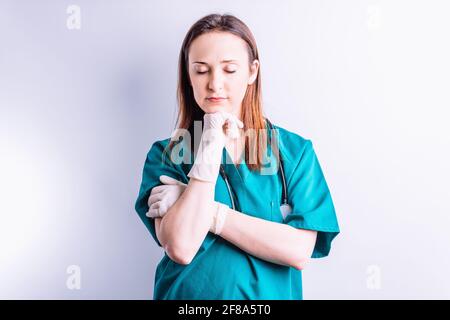 Krankenhausarzt Chirurg mit Stethoskop und Handschuhen mit geschlossenen Augen Müde lehnte sich auf ihre Hand .Krankenhaus Medizin Konzept Stockfoto