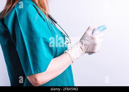 Arzt in Krankenhauskleidung mit einem Laserthermometer auf Weiß Hintergrund Stockfoto