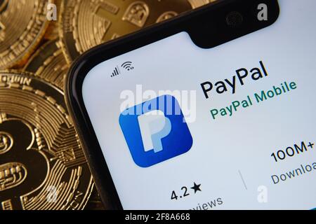 PayPal-App auf dem Smartphone-Bildschirm gesehen auf der Spitze Bitcoin Münzen Haufen platziert. Konzept. Stafford, Großbritannien, 12. April 2021. Stockfoto