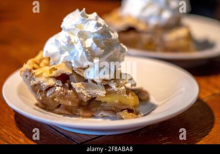 Scheiben hausgemachten Apfelkuchen mit Schlagsahne gekrönt Stockfoto