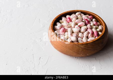 Bunte rosa und weiß geschälte Cranberry Borlotti Bohnen in Holz Schüssel Stockfoto