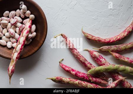 Bunte Cranberry Borlotti Shell Bohnen mit geschälten Bohnen und einer Split Bean in Holzschale Stockfoto