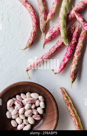 Bunte Cranberry Borlotti Shell Bohnen mit Holzschale auf Weißer Hintergrund Stockfoto