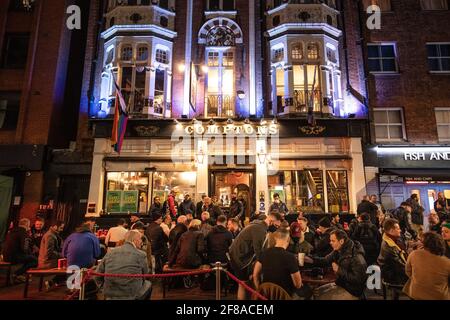 London, Großbritannien. 13. April 2021. Menschen versammeln sich in Soho, London, wo Straßen für den Verkehr gesperrt wurden, als Bars und Restaurants für Essen und Trinken im Freien geöffnet wurden, da die Sperrmaßnahmen in ganz Großbritannien gelockert werden. Bilddatum: Dienstag, 13. April 2021. Bildnachweis sollte lauten: Matt Crossick/Empics/Alamy Live News Stockfoto