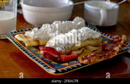 Köstliche Erdbeercrepes werden mit süßer Schlagsahne und gekrönt Serviert mit Speck Stockfoto