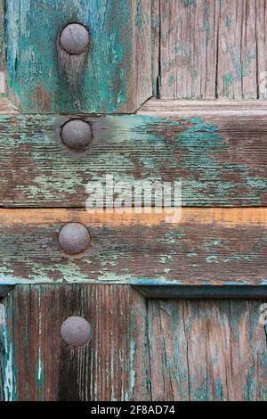 Abstract Nahaufnahme einer Holztür mit schälenden grünen Farben und Metallschrauben in New Orleans, Louisiana Stockfoto