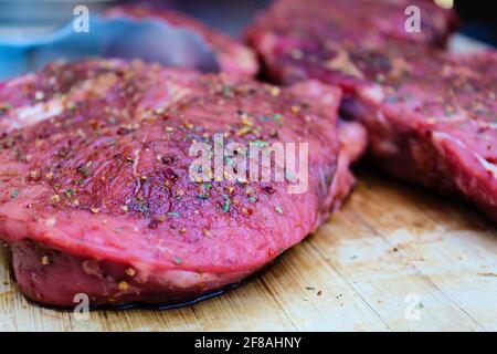 Mariniert mit Gewürzen rohes grillfleisch auf einem Holz. Sommerkonzept Stockfoto