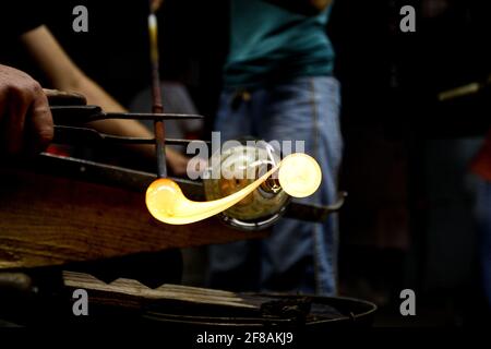 Werk Neman, Glasbläser, Berezovka. Kristallproduktion, Glasmuseum, Vase, Breschnev Myagkov Glasbläser bilden das schöne Stück Glas. Der Glasmeister verbrennt und bläst das Kunstwerk aus Stockfoto