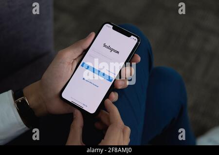 CHIANG MAI, THAILAND - APR 6 2021: Frau Hand hält iphone mit Login der instagram-Anwendung. Instagram ist das größte und beliebteste Foto Stockfoto