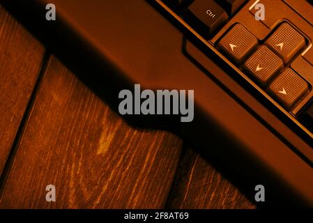 Gaming-Computer-Tastatur auf einem Holztisch. Nach-oben- und nach-unten-Tasten auf einer Computertastatur. Stockfoto