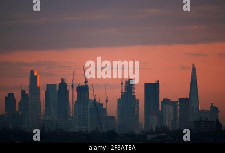 London, Großbritannien. 13. April 2021. Die Morgenröte bricht über den Wolkenkratzern im Zentrum Londons an, und das Sonnenlicht reflektiert die oberen Stockwerke von 22 Bishopsgate, dem 62-stöckigen, 912 Fuß hohen Bürogebäude in der City of London. Quelle: Malcolm Park/Alamy Live News. Stockfoto