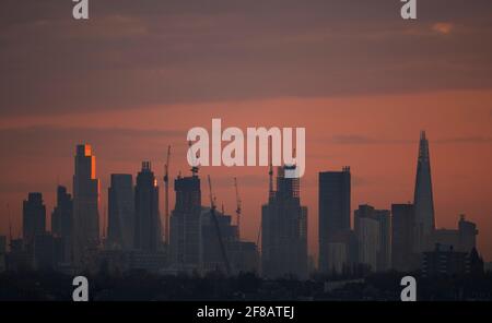 London, Großbritannien. 13. April 2021. Die Morgenröte bricht über den Wolkenkratzern im Zentrum Londons an, und das Sonnenlicht reflektiert die oberen Stockwerke von 22 Bishopsgate, dem 62-stöckigen, 912 Fuß hohen Bürogebäude in der City of London. Quelle: Malcolm Park/Alamy Live News. Stockfoto