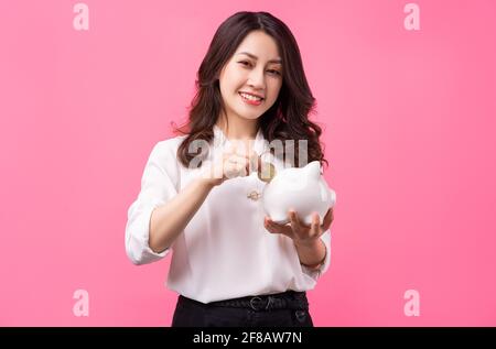 Asiatische Geschäftsfrau hält Schweinchen in der Hand, Geld sparen Konzept Stockfoto