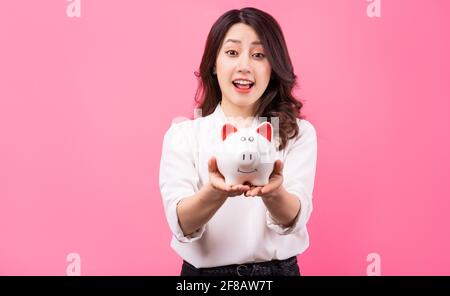 Asiatische Geschäftsfrau hält Schweinchen in der Hand, Geld sparen Konzept Stockfoto