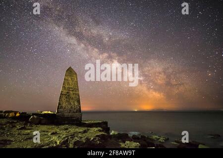 Portland Bill, Dorset, Großbritannien. April 2021. Wetter in Großbritannien. Das galaktische Zentrum der Milchstraße leuchtet hell am klaren Nachthimmel über dem Obelisken bei Portland Bill an der Dorset Jurassic Coast. Bildnachweis: Graham Hunt/Alamy Live News Stockfoto