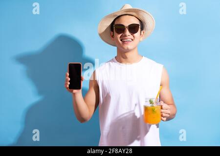 Hübscher asiatischer Mann mit Sonnenbrille und Cocktail in der Hand Über Telefon Stockfoto