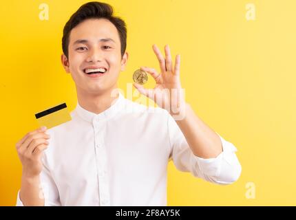 Asiatischer Geschäftsmann hält Bitcoin in der Hand und hat ein glückliches Gesicht Stockfoto