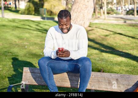 Nahaufnahme der Hände eines schwarzen Mannes, die mit einem Smartphone eine Nachricht senden. In sozialen Netzwerken surfen. Konzept der Technologie. Hochwertige Fotos Stockfoto