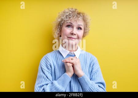 Gealterte Grauhaarige Frau, Die Die Hände Zusammenhält Und Die Kamera Anschaut, Die Freundlich Und Angenehm Aussieht. Isoliertes Hochformat Stockfoto