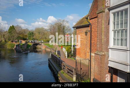 Kennet und Avon Kanal und Schleusentor, Fußweg am Fullers Pub Lock Stock and Barrel an einem sonnigen Tag mit Bäumen in der Ferne. Newbury, Bekshire. Stockfoto