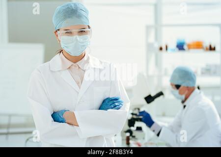 Nahaufnahme. Arzt in einer Schutzmaske im Labor stehend. Stockfoto