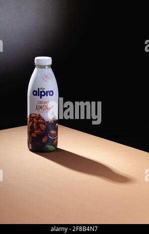 Prag, Tschechische Republik - 22. März 2021: Alpro-Mandelgetränk und Schatten auf dem braunen Tisch. Alpro ist ein europäisches Unternehmen, das organische und nicht-Org-Produkte vermarktet Stockfoto