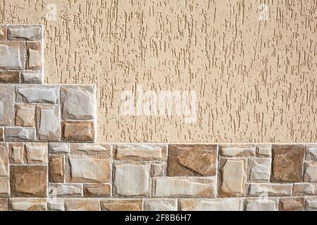 Steinfliesen in Form von Stufen aus rechteckigen Fragmenten von Beige- und Sandfarbe und Putz an der Wand mit einem Rindenkäfer-Muster. Hintergrund, Stockfoto