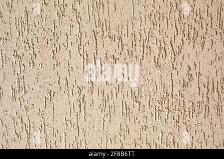 Putz an der Wand mit einem Rindenkäfer-Muster in Beige und Sandfarbe. Hintergrund, Textur. Außendekoration des Gebäudes, Haus. Stockfoto