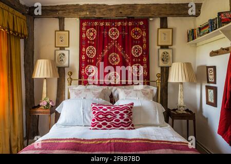 Suzani Wand hängen in Klasse II aufgeführt Suffolk Bauernhaus Schlafzimmer. Stockfoto