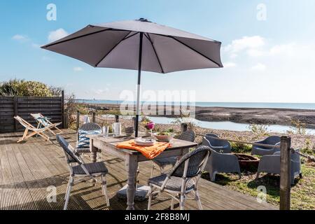 Paarasol Schattiertisch und Stühle auf der Terrasse des West Sussex Ferienhauses. Stockfoto