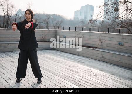 Eine Expertin aus taijiquan hängend die Hände allein auf das Dach Stockfoto