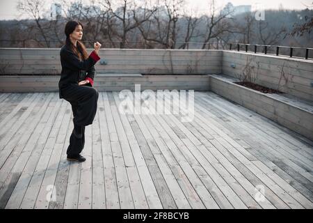 Leerer Außenbereich mit Frau, die in Chi-Kung-Haltung steht Stockfoto