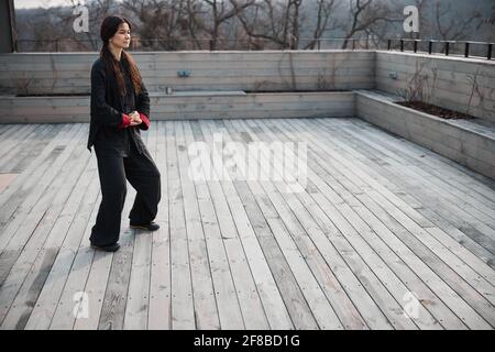 Tai Chi Lernende faltet die Hände vor dem Bauch Stockfoto