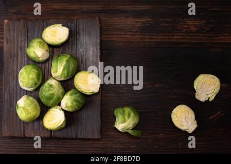 Frische rosenkohl auf dunklem Holzhintergrund, rustikaler Stil, gesundes Essen, Nahaufnahme. Stockfoto