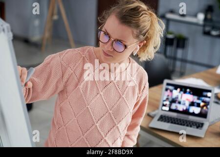 Lehrerin, die zu Hause auf der Tafel schreibt Stockfoto