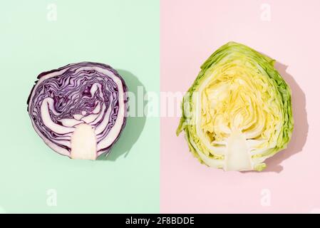 Hälften roter und früher Kohlköpfe auf grünem und pinkem Hintergrund, Collage aus zwei Kohlsorten, Nahaufnahme. Stockfoto