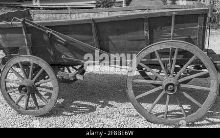 Graustufenaufnahme eines alten leeren viktorianischen Waggons Felsiger Boden Stockfoto