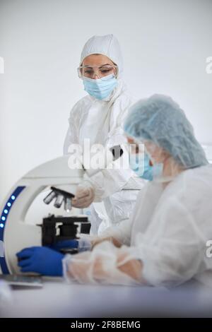 Wissenschaftler in Hazmat-Anzügen untersuchen eine Virusprobe Stockfoto