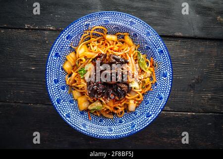 Mushroom udon Nudeln auf dem dunklen Holzhintergrund Stockfoto