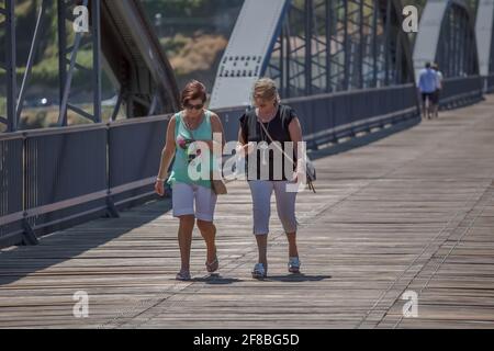 Regua / Portugal - 10/02/2020 : Blick auf eine touristische Frau, die durch die Metallbrücke der Stadt Peso da Regua schlendert Stockfoto