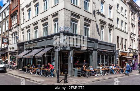 Kunden, die einen sonnigen Tag im Balans Soho Society Restaurant, Old Compton Street, Soho, London, W1D, England, Großbritannien. Stockfoto