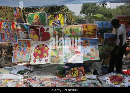 Naogaon, Bangladesch. April 2021. Ein Verkäufer arrangiert seinen Plakatladen auf einer Dorfmesse, um das Poush Sankranti Festival in der Nähe von Kashipur im Naogaon-Distrikt, nördlich von Bangladesch, zu feiern. Poush Sankranti ist auch als Makar Sankranti bekannt, die am letzten Tag des bengalischen Poushmonats gefeiert wird. Quelle: MD Mehedi Hasan/ZUMA Wire/Alamy Live News Stockfoto