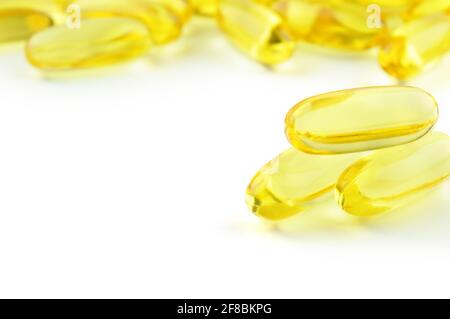 Kapseln Omega 3 isoliert auf weißem Hintergrund und viele andere Kapseln auf verschwommenem Hintergrund. Nahaufnahme, hochauflösendes Produkt. Gesundheitskonzept Stockfoto