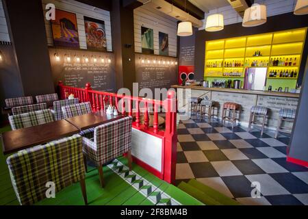 Leeres Café ohne Besucher. Holztheke im orientalischen Restaurant. Stühle und Tische in einer stilvollen Cafeteria mit farbenfrohen Wänden Stockfoto