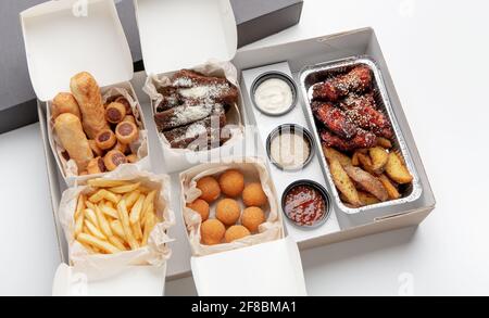 Junk-Mahlzeit, leckere Snacks, modernes Fast-Food-Menü und Lieferung an den Kunden während der Sperre des Covid-19 Stockfoto