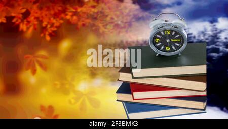 Ein Wecker, der auf einem Stapel von steht Bücher Stockfoto