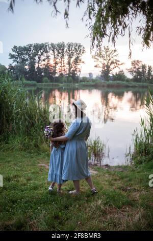 Die Mutter umarmt ihre Tochter im Freien in der Natur Stockfoto