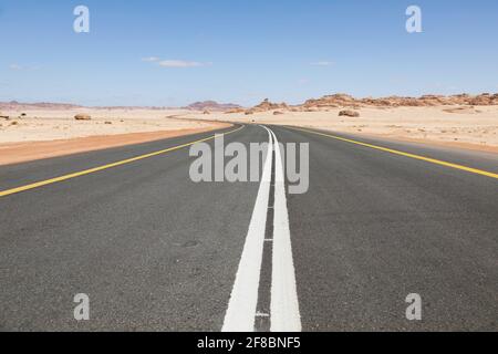 Typische Straße in Saudi-Arabien, die durch die Wüste führt Stockfoto