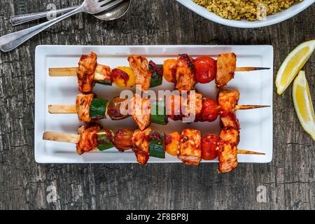 Würziges Huhn, Tomaten und Zucchini-Spieße mit Couscous - Blick von oben Stockfoto