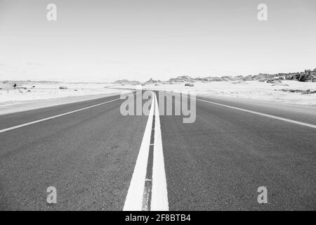 Typische Straße in Saudi-Arabien, die durch die Wüste führt Stockfoto